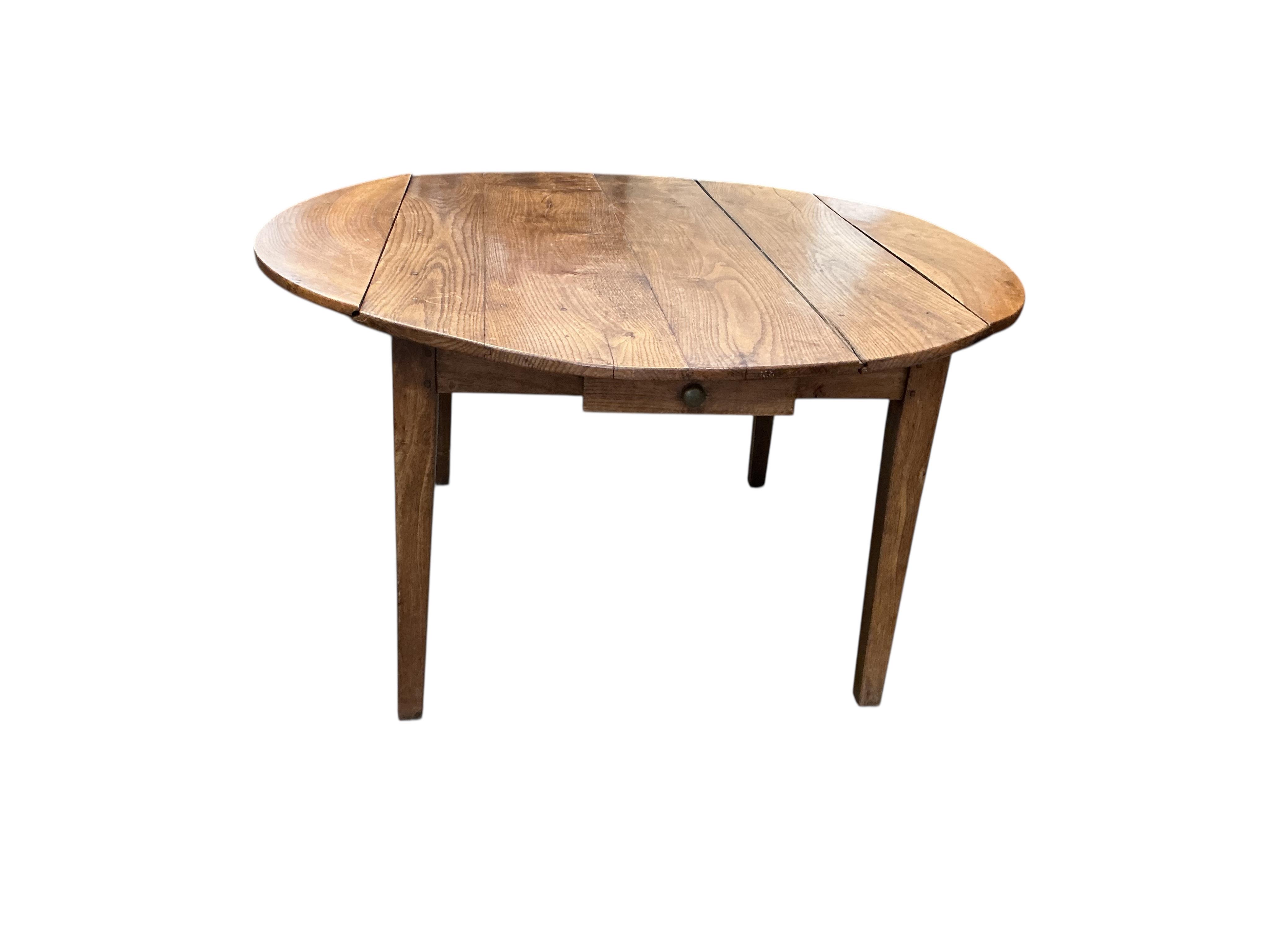 A 19th century French Provincial oak drop leaf dining table, diameter 138cm, extended, height 73cm